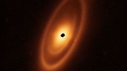 This image of the dusty debris disc surrounding the young star Fomalhaut is from Webb's Mid-Infrared Instrument (MIRI). It reveals three nested belts extending out to 23 billion kilometres from the star. The inner belts — which had never been seen before — were revealed by Webb for the first time. The NASA/ESA Hubble Space Telescope and ESA's Herschel Space Observatory, as well as the Atacama Large Millimeter/submillimeter Array (ALMA), have previously taken sharp images of the outermost belt. However, none of them found any structure interior to it. These belts are most likely shaped by the gravitational forces produced by unseen planets. [Image description: An orange oval extends from the 1 o'clock to 7 o'clock positions. It features a prominent outer ring, a darker gap, an intermediate ring, a narrower dark gap, and a bright inner disc. At the centre is a ragged black spot indicating a lack of data.]