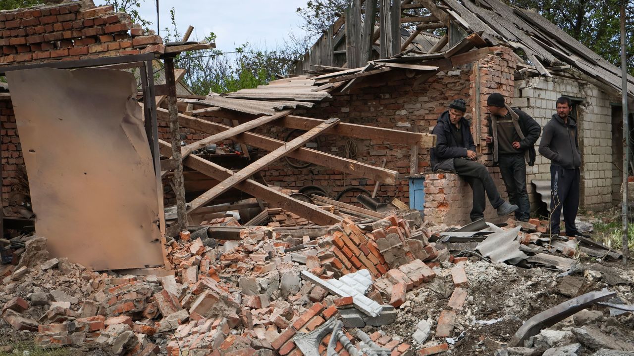 Los residentes locales se paran cerca de un edificio dañado durante la noche después del bombardeo ruso en Komyshevakha, región de Zaporizhia, Ucrania, el lunes 8 de mayo. 