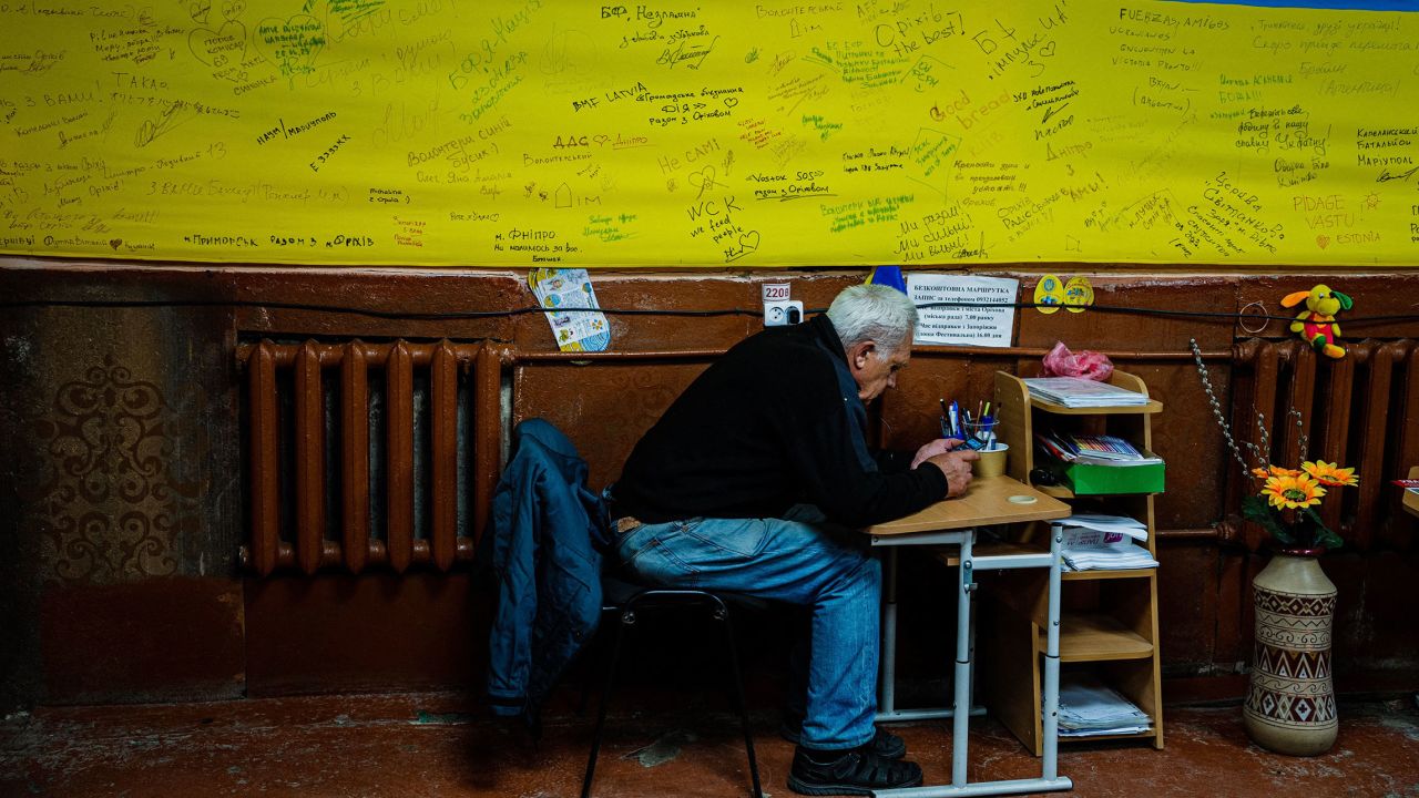 A local resident checks his phone in a volunteer-run shelter in the town of Orikhiv, in the Zaporizhzhia region, on May 7.