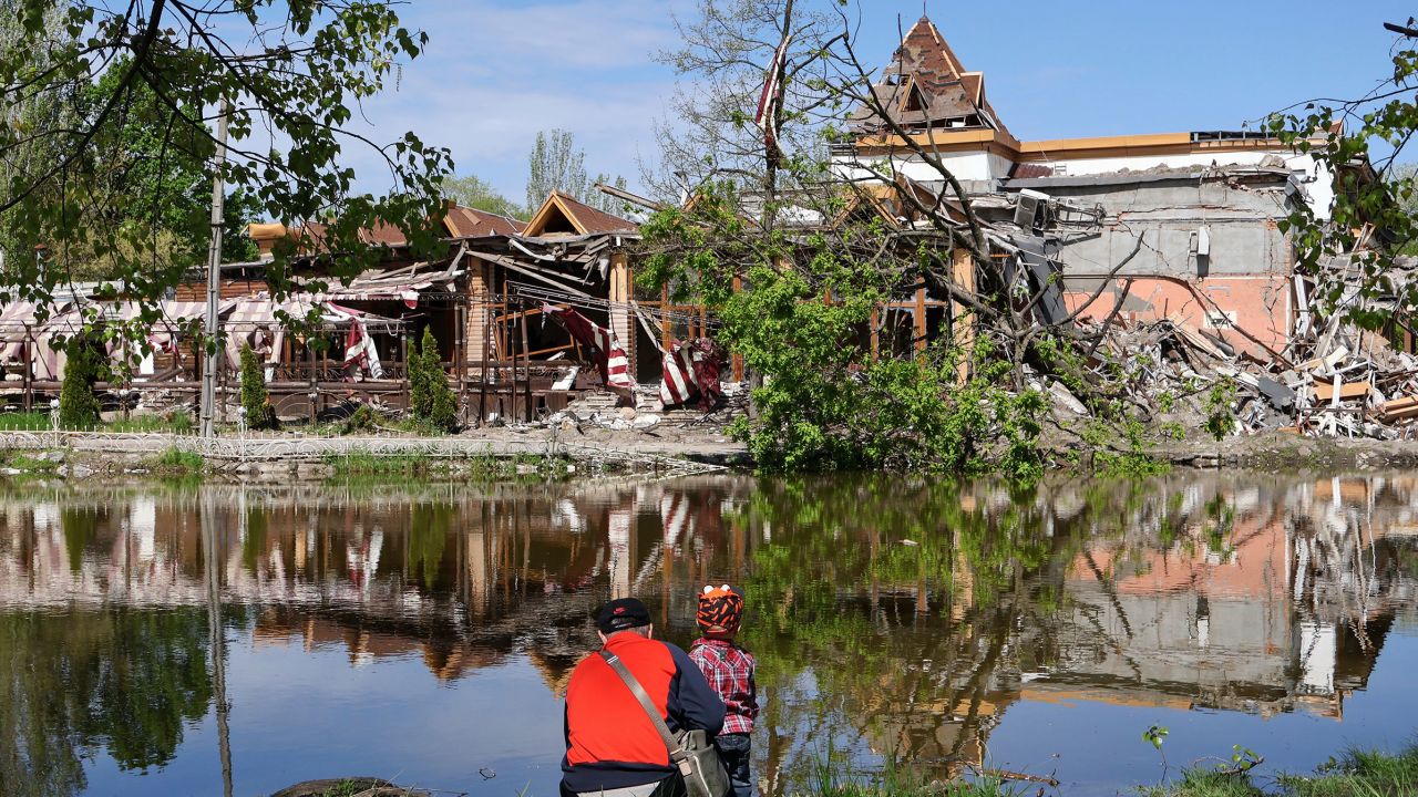 Un hombre y un niño miran el destruido hotel Sunrise Park en Zaporizhia después del bombardeo ruso el 5 de mayo. 