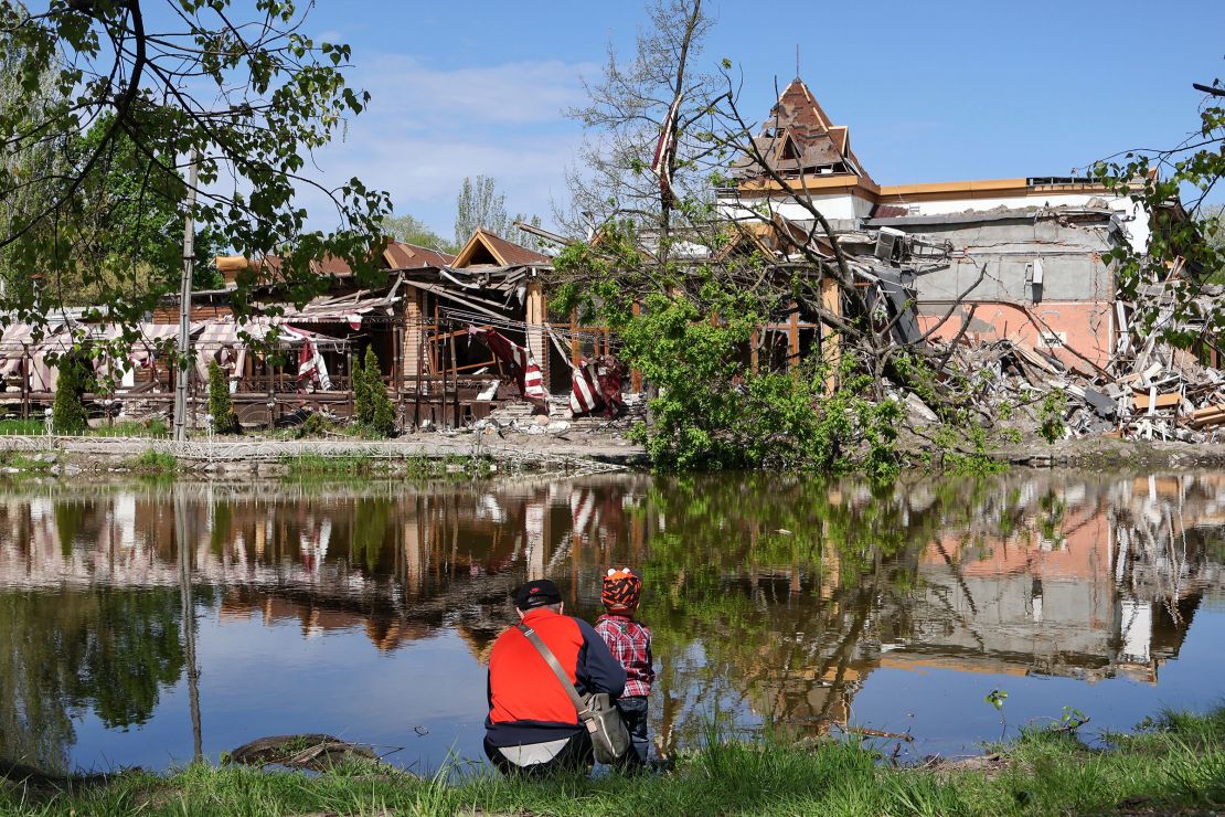 A man and a child look at the destroyed Sunrise Park Hotel in Zaporizhzhia after the Russian shelling on May 5. 