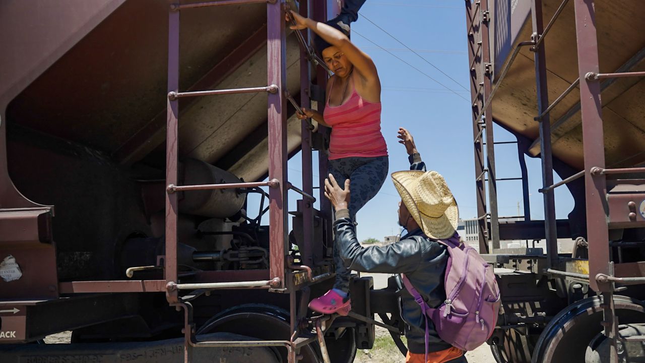 Relatives help a woman get off the train after she became too scared to climb down from the roof