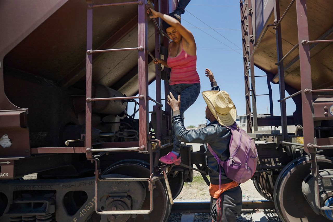 A woman is helped off a freight train after she became too scared to climb down from the roof on Sunday, May 7. <a href=