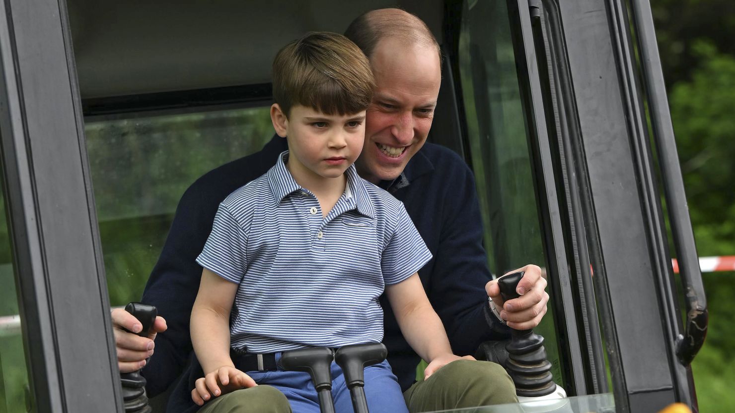 Prince Louis helped his father, the Prince of Wales, use an excavator while taking part in the Big Help Out, during a visit to the 3rd Upton Scouts Hut.