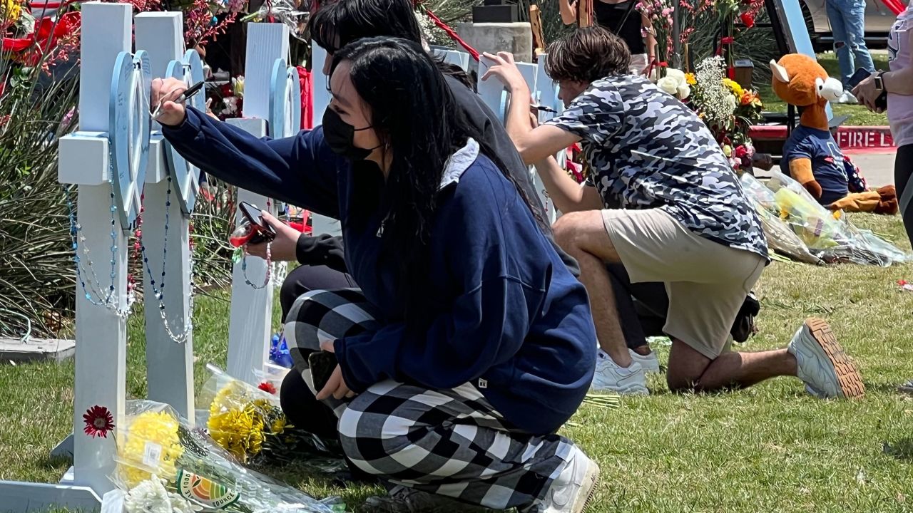 Mourners gather at a makeshift memorial Monday for victims of the massacre at Allen Premium Outlets.
