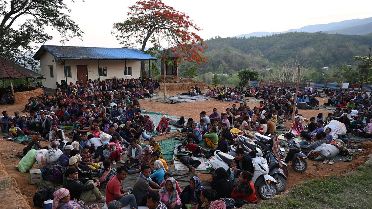 People wait at a temporary shelter in a military camp, after being evacuated by the Indian army, as they flee ethnic violence that has hit the northeastern Indian state of Manipur on May 7, 2023. 