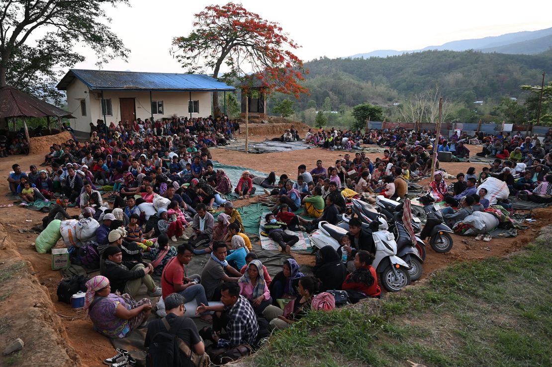 People wait at a temporary shelter in a military camp, after being evacuated by the Indian army, as they flee ethnic violence that has hit the northeastern Indian state of Manipur on May 7, 2023. 
