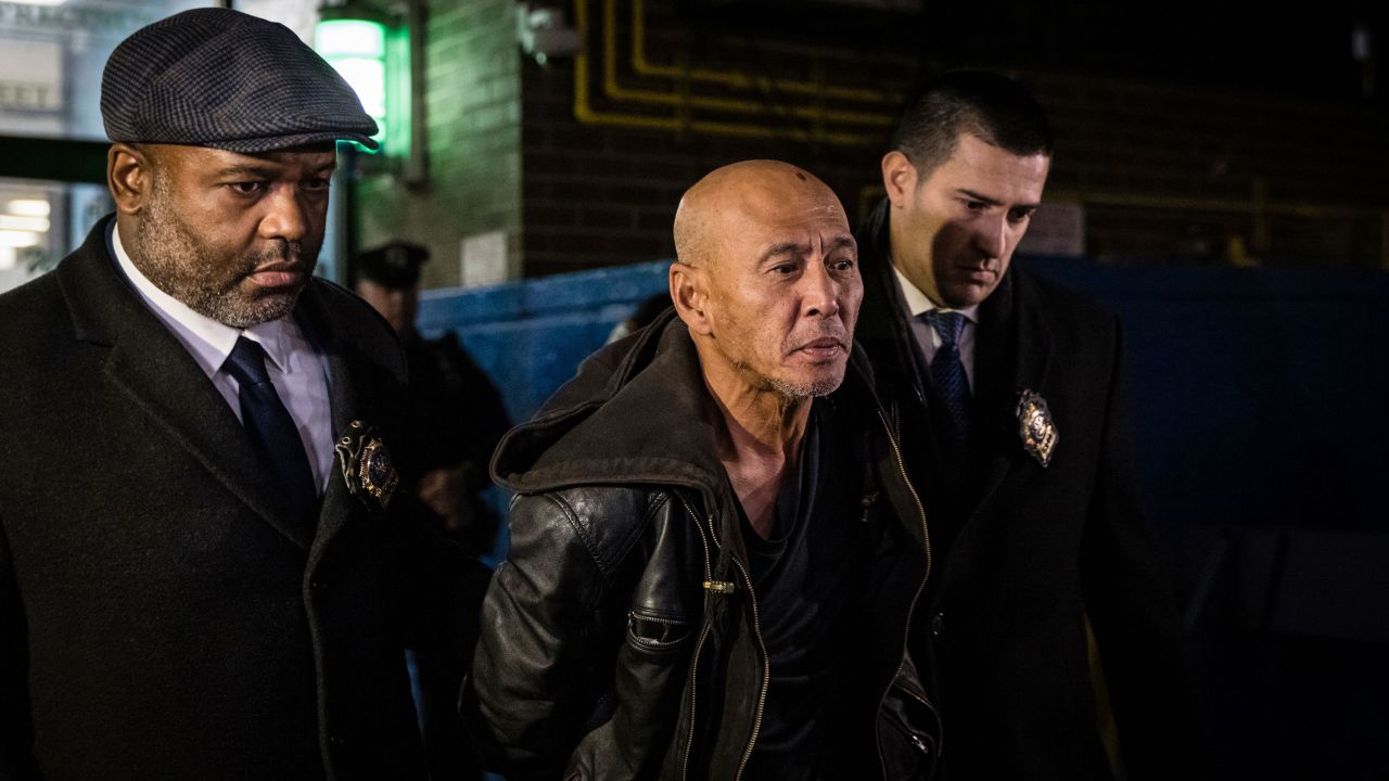 Detectives walk Weng Sor, center, out of a police precinct building in Brooklyn on February 14.