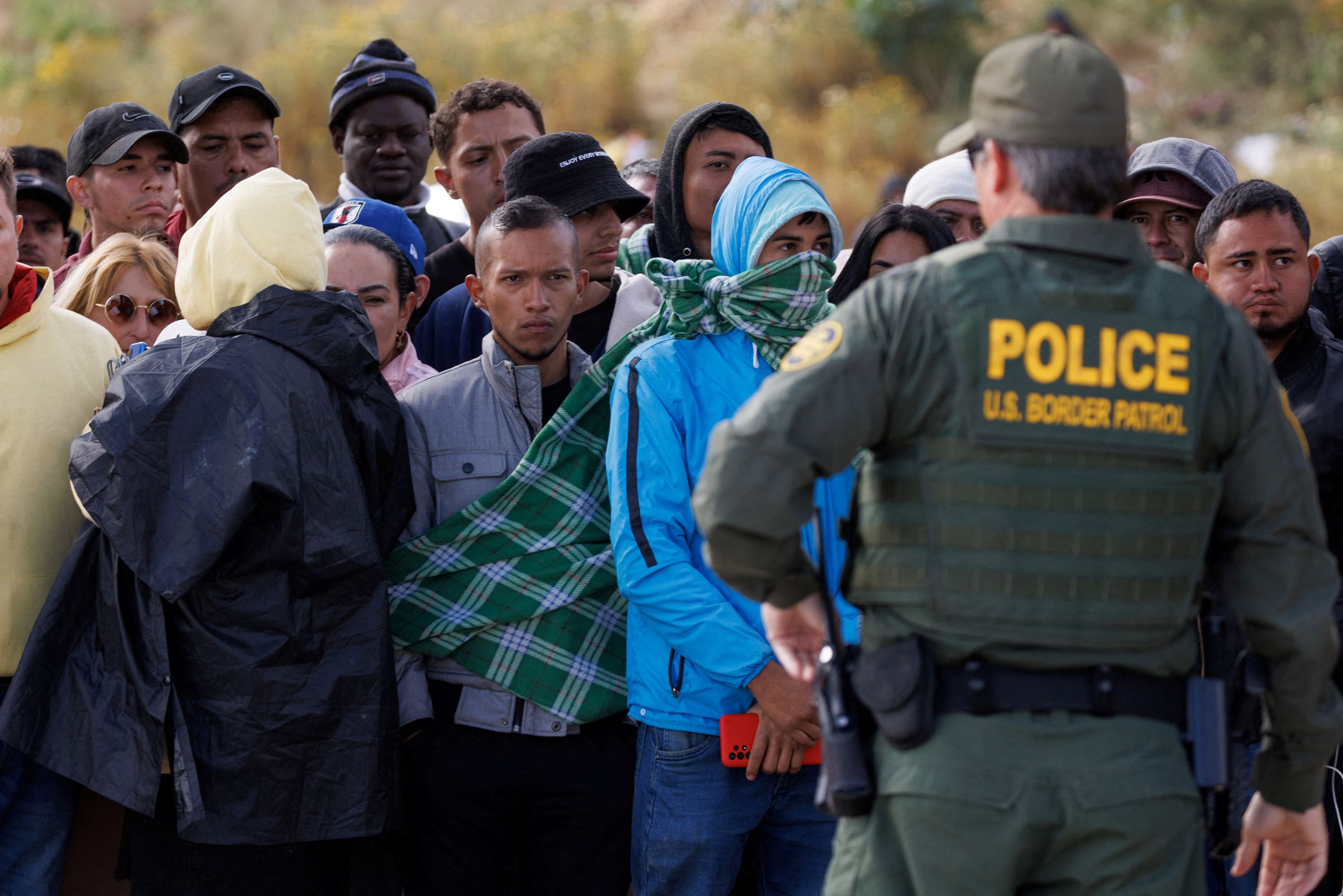 A US Border Patrol agent watches over migrants who had gathered in San Diego on May 8.