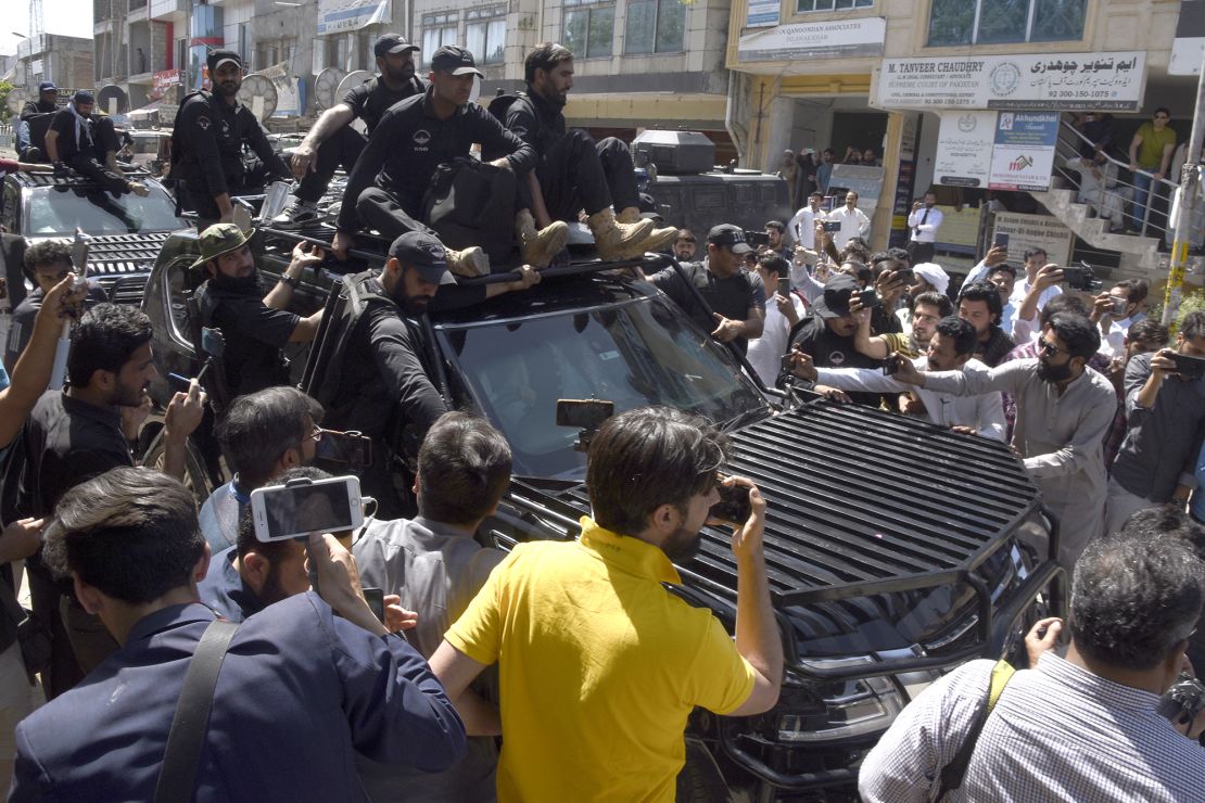 Private security personnel clear the way for a vehicle carrying Pakistan's former Prime Minister Imran Khan to a court appearance, in Islamabad on May 9. 