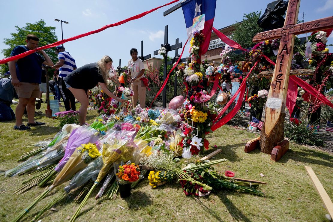 Mourners leave flowers at a makeshift memorial for the victims of the mass shooting in Allen, Texas.