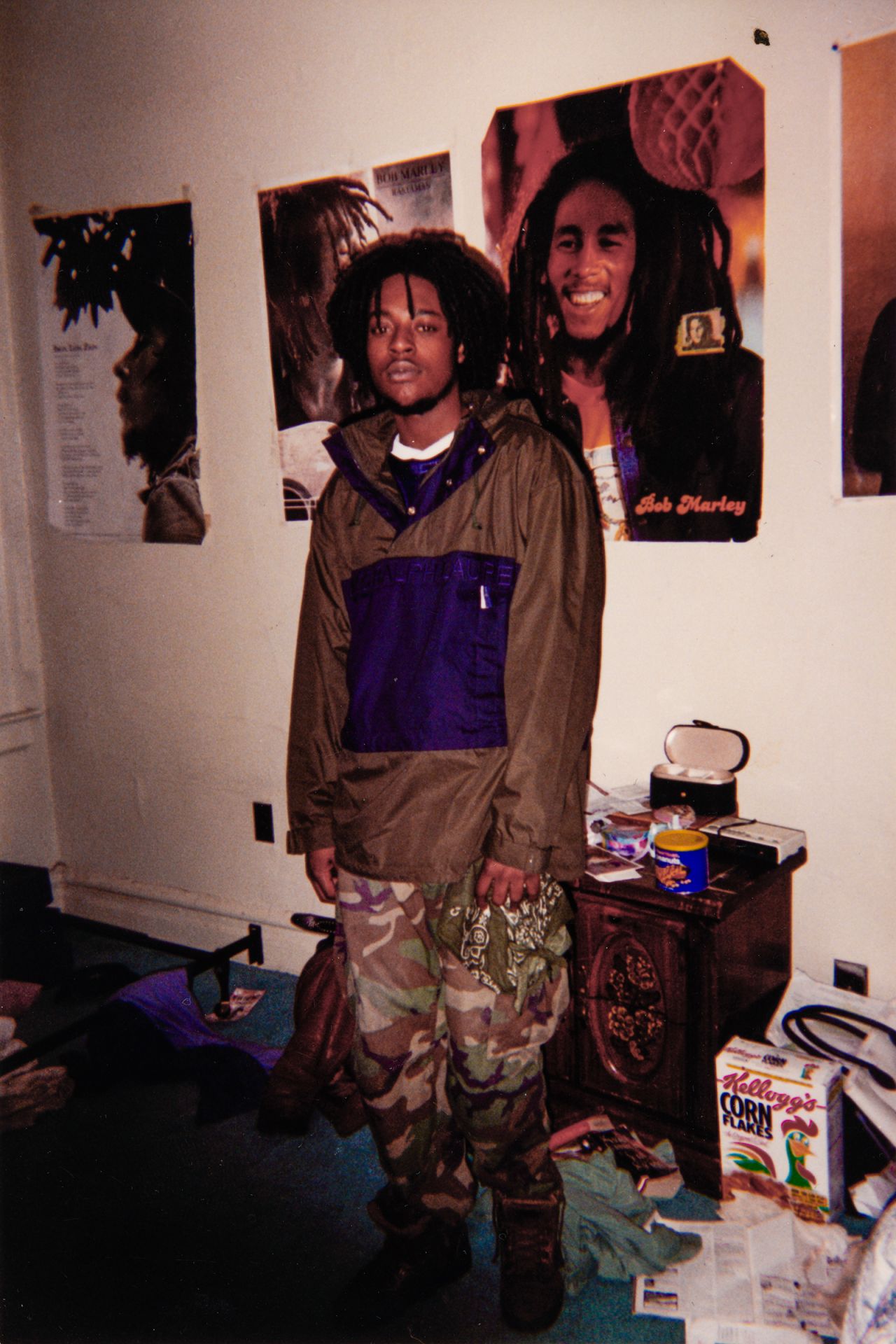 An old photo shows Akil's father, originally from Jamaica, with posters of reggae legend Bob Marley.