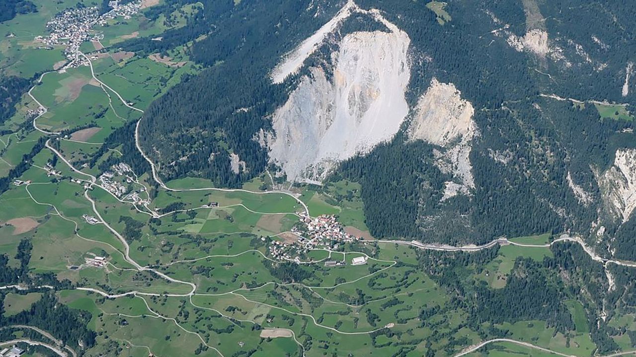 An aerial view shows the village of Brienz, with the unstable slope towering above.