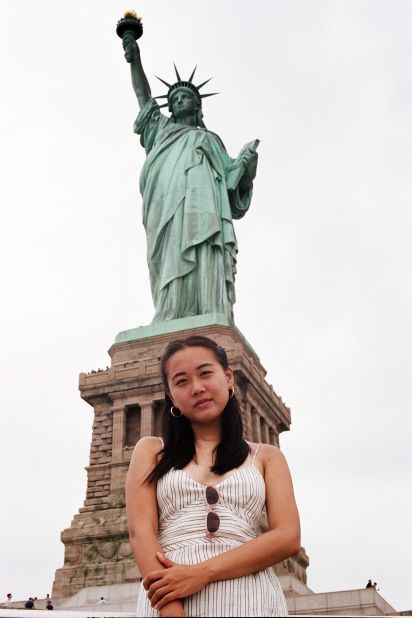 Amy poses in front of the Statue of Liberty in New York.