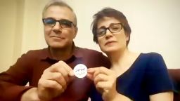 Iranian human rights lawyer Nasrin Sotoudeh and husband Reza Khandan hold up a protest button which reads: 'I oppose the mandatory hijab,' during their conversation over Zoom with film director Jeff Kaufman.