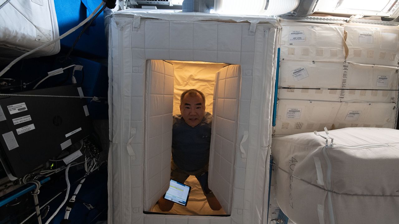 El exastronauta de la Agencia de Exploración Aeroespacial de Japón, Soichi Noguchi, se encuentra dentro de una estación para dormir en la estación espacial en abril de 2021.