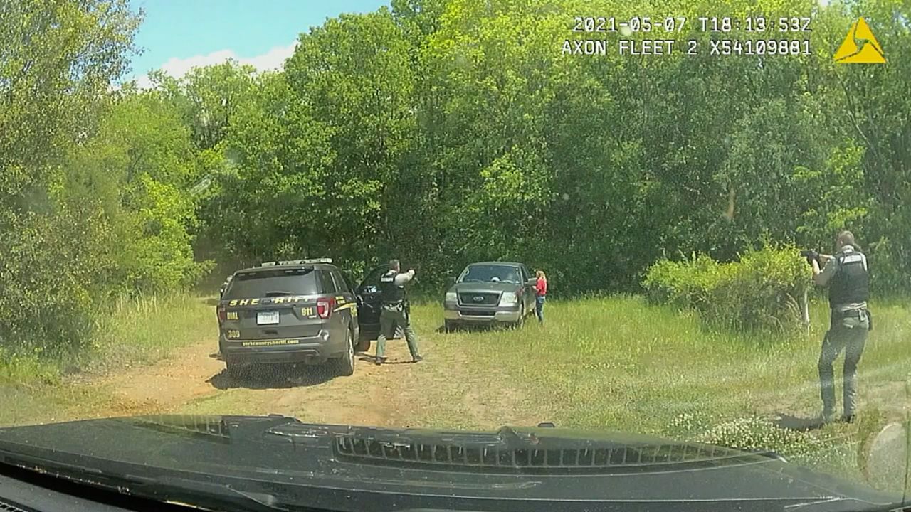 An image taken from video released by the York County Sheriff's Office shows the scene moments before officers opened fire on Mullinax's truck with him inside and his mother, seen in red, standing beside it on May 7, 2021.