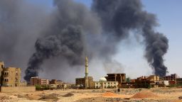 A man walks while smoke rises above buildings after aerial bombardment, during clashes between the paramilitary Rapid Support Forces and the army in Khartoum North, Sudan, May 1, 2023. REUTERS/Mohamed Nureldin Abdallah     TPX IMAGES OF THE DAY