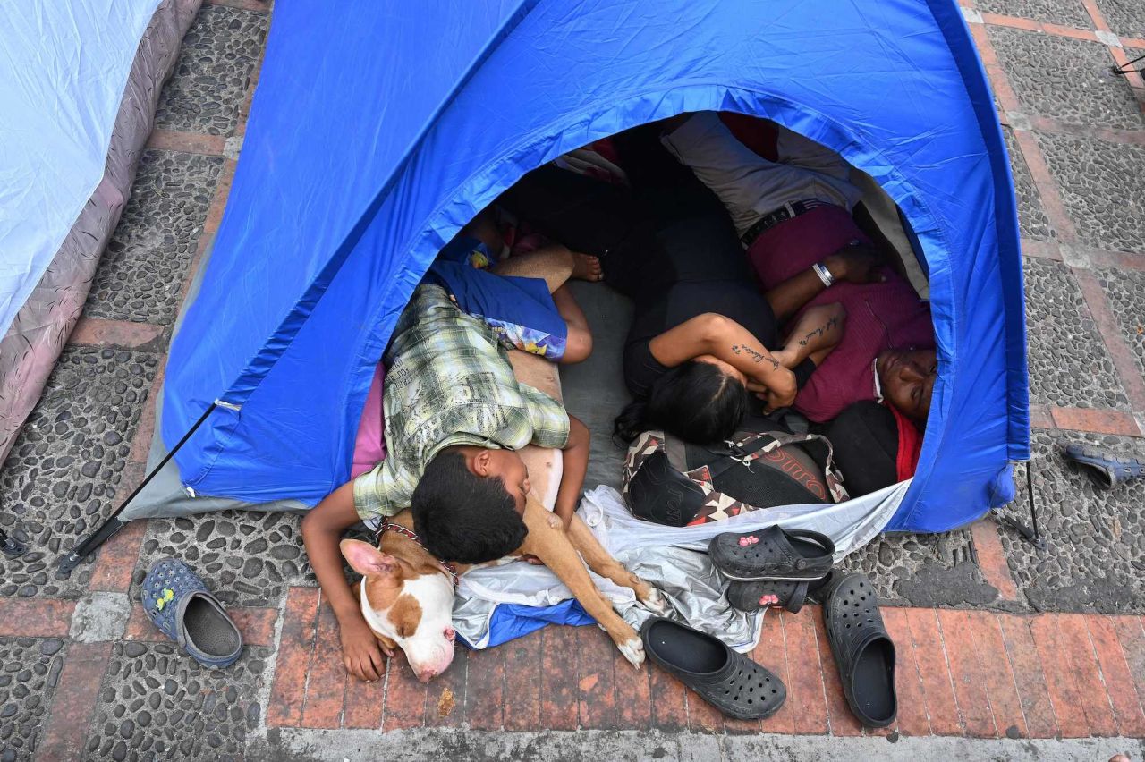 Venezuelan migrants rest in a tent outside the Central Bank of Honduras in Tegucigalpa on May 10. They were waiting to withdraw money to continue their journey to the United States.