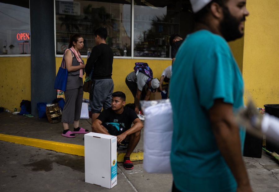 Migrants wait to get paid after washing cars at a gas station in Brownsville on May 10. They had arrived the day before from Mexico.