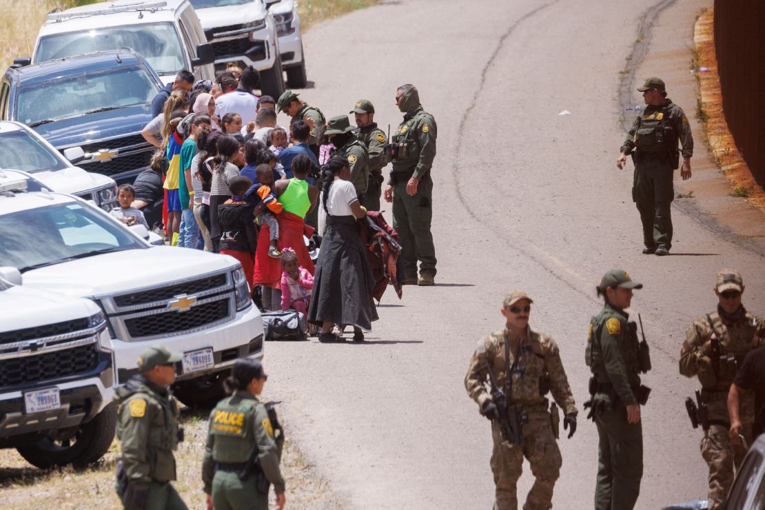 US border patrol personnel organize a group of families near San Diego, California, on Tuesday.