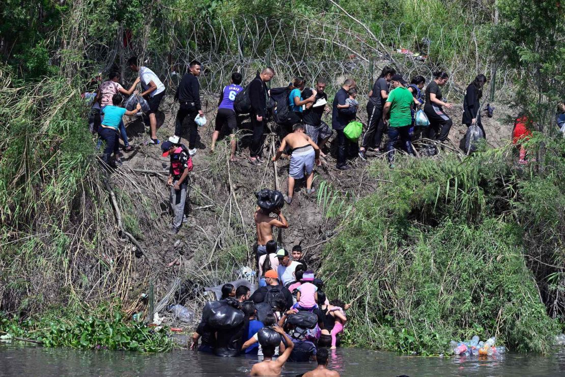 Migrants try to get to the US through the Rio Grande, which is reinforced with a barbed-wire fence, as seen from Matamoros, Mexico, on Wednesday.
