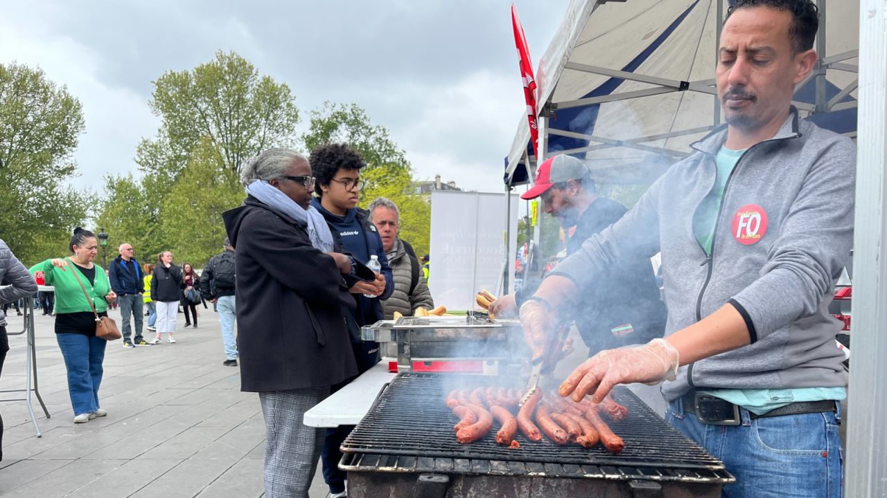 Ibrahim Lamhin, a grill man for labor union Force Ouvrière, cooking sausages at a protest in the center of Paris.