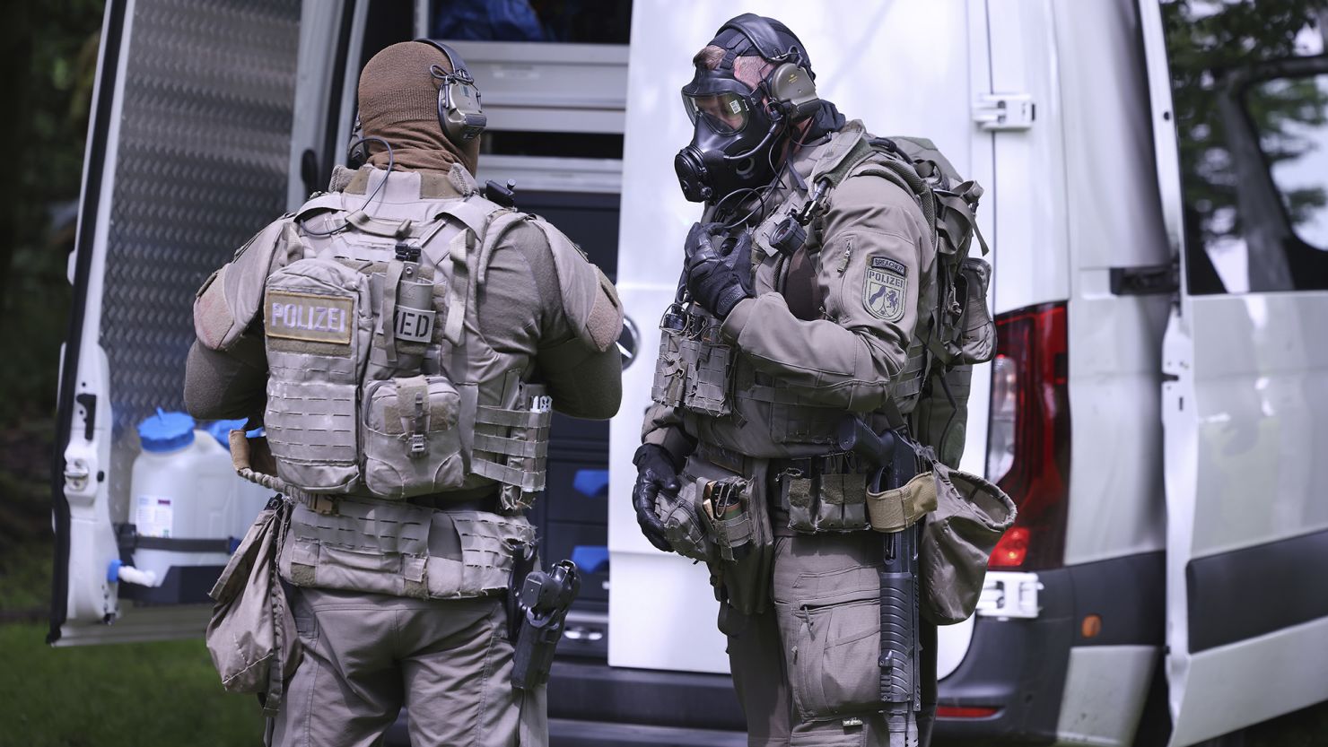 A police officer wearing a gas mask stands next to a colleague in front of a high-rise building in Ratingen on Thursday morning.
