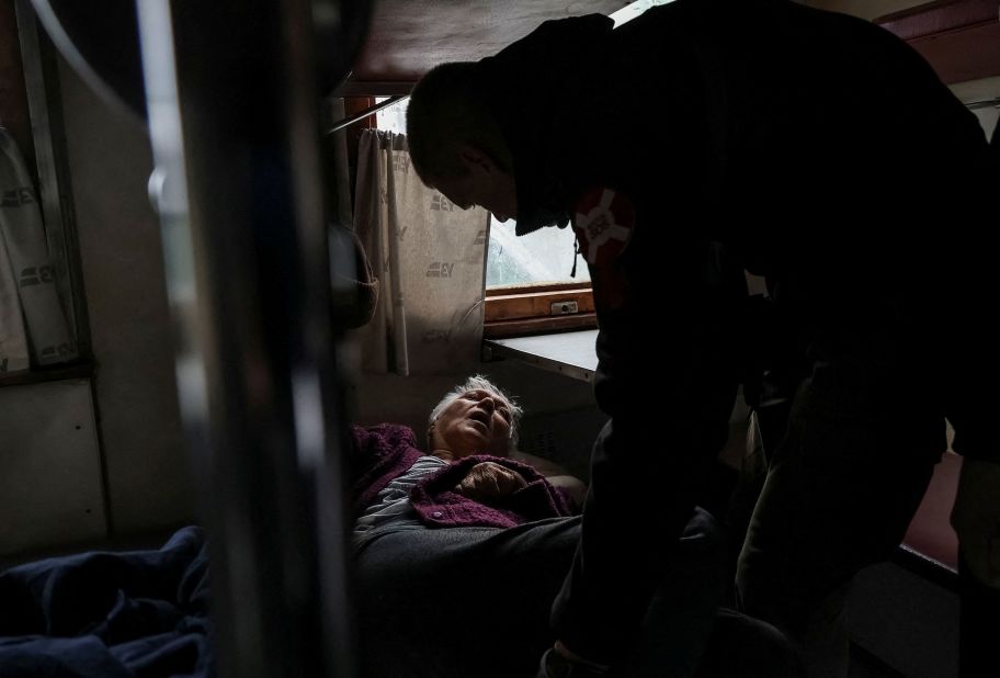 A volunteer helps an elderly woman board an evacuation train in Pokrovsk, Ukraine, on Wednesday, May 10.