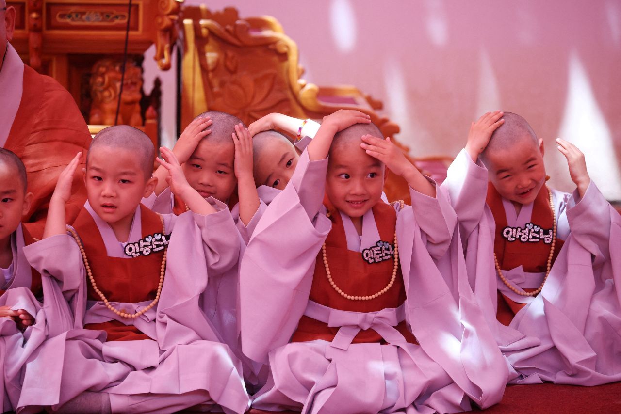 Novice monks in Seoul, South Korea, react after getting their heads shaved Tuesday, May 9, during an event to celebrate the upcoming <a href=