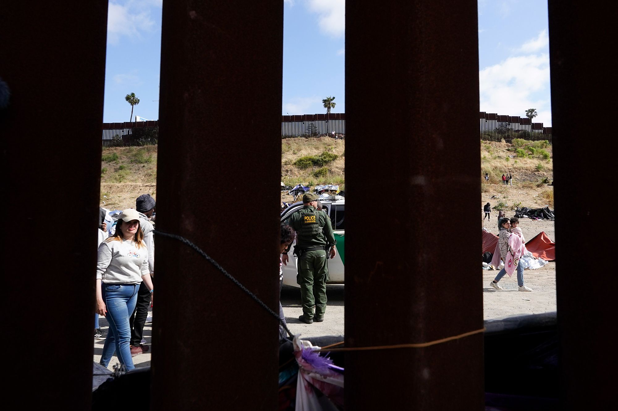 A US Border Patrol agent looks on as migrants wait to apply for asylum near San Diego on May 11.