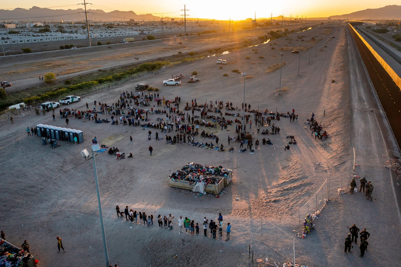 As the sun sets on May 11, migrants wait to be processed by US Border Patrol agents across the border from El Paso.