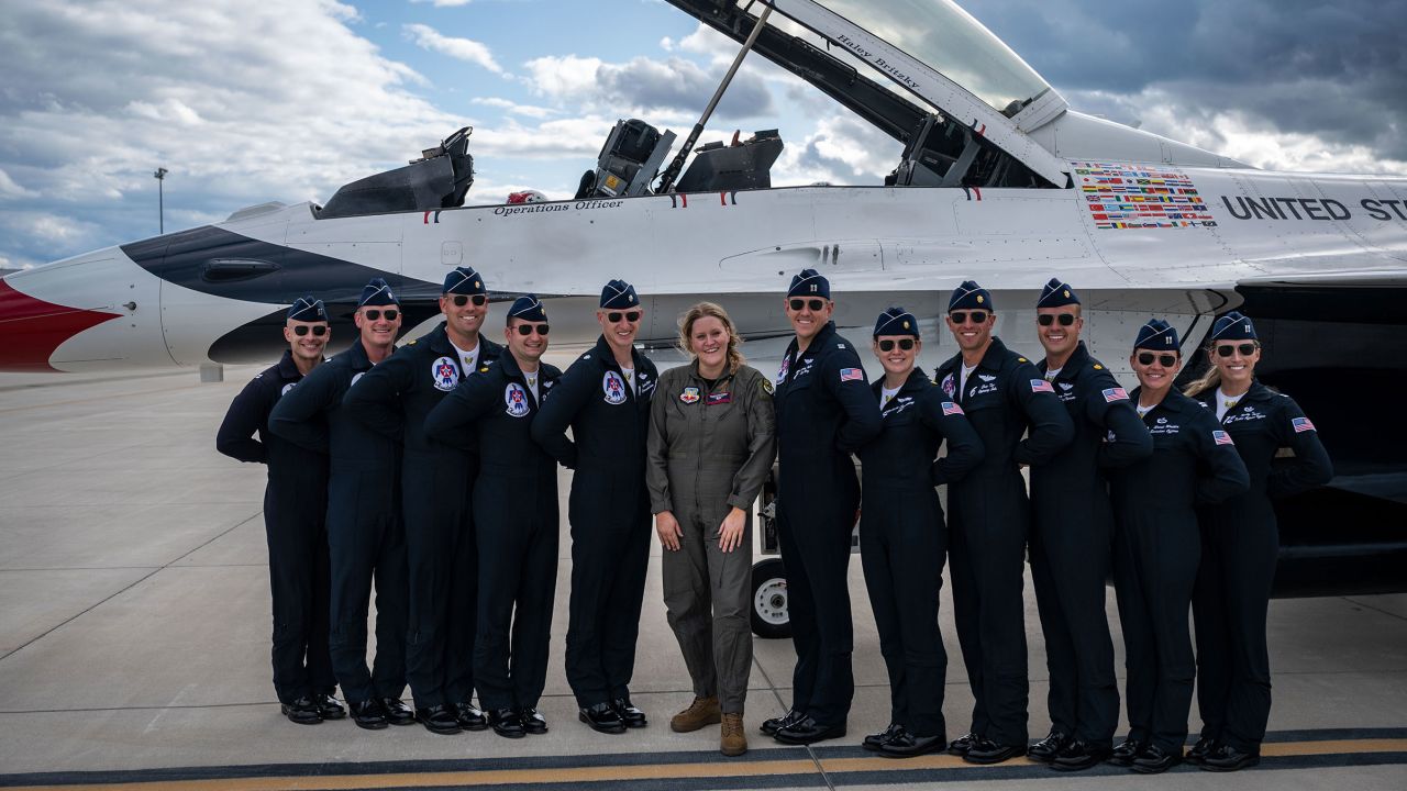 Haley Britzky, a CNN Pentagon reporter, and members of the US Air Force Thunderbird team pose for a photo in front of the Thunderbird F-16 Fighting Falcon after its takeoff.  There are eight pilots assigned to the USAF Thunderbirds and each has more than 1,000 flight hours, with a combined total of more than 15,000 flight hours.