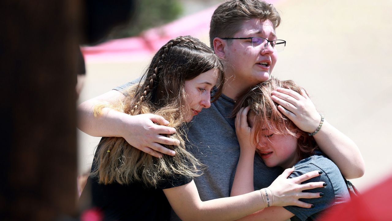 Visitors seen hugging at a memorial set up near the scene of a mass shooting at the Allen Premium Outlets mall on May 8, 2023 in Allen, Texas. 