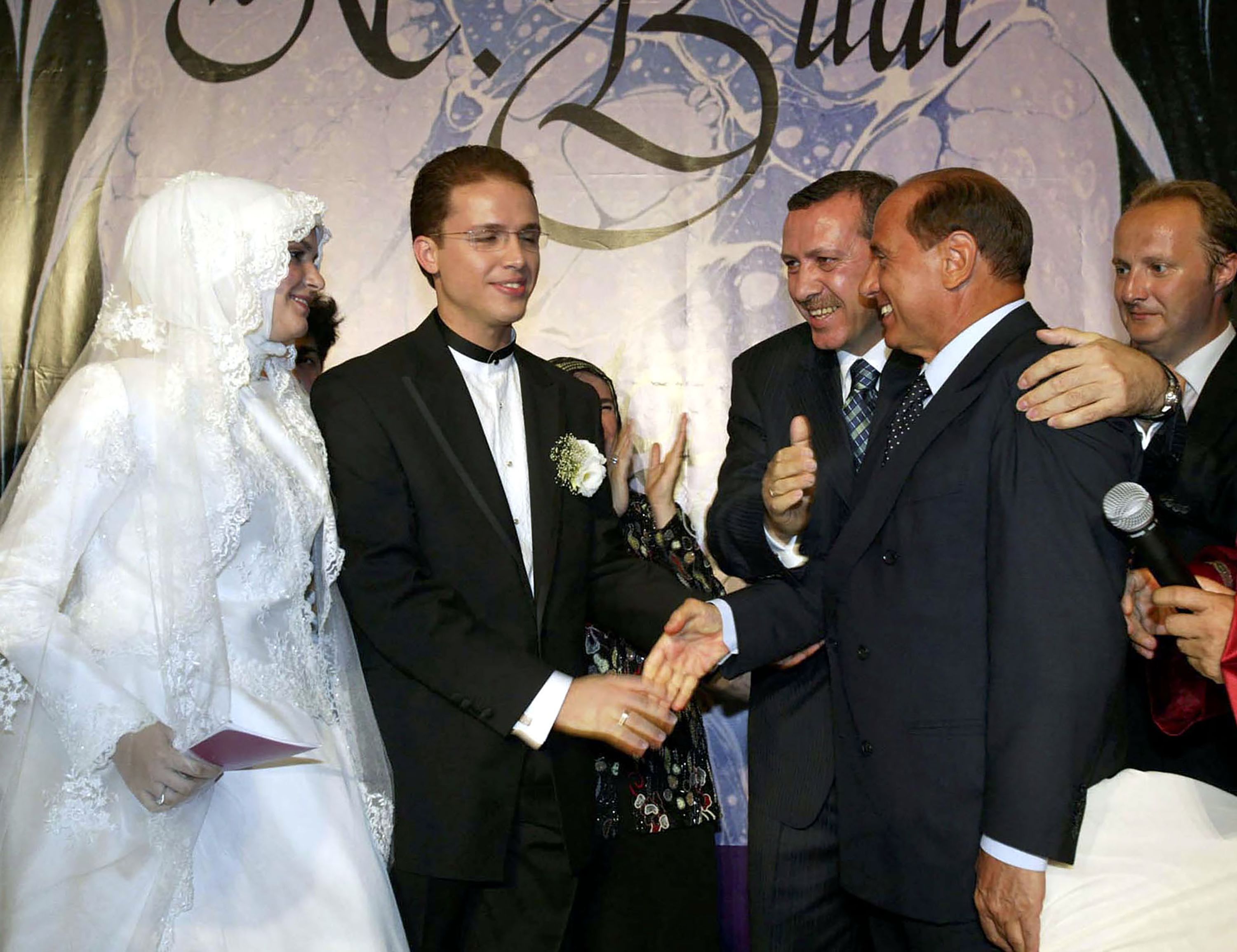 Erdogan embraces Italian Prime Minister Silvio Berlusconi at his son's wedding in August 2003.