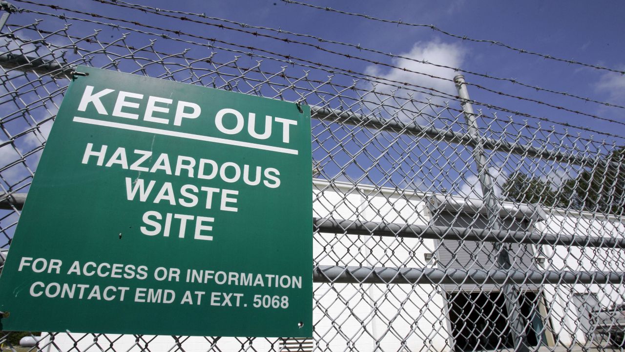 FILE -  In this May 9, 2007, file photo a sign is posted at an ongoing cleanup pump and treatment center operated by Shaw Corp. on lot 203 at Camp Lejeune, N.C., to treat the underground plume of TCE, trichloroethylene, created by a waste disposal site on the Marine base.  In an about face Tuesday, April 28, 2009, the U.S. government disavowed a 12-year-old federal report that found little or no cancer risk for adults who lived on the base where drinking water was contaminated for three decades.  (AP Photo/Gerry Broome, File)