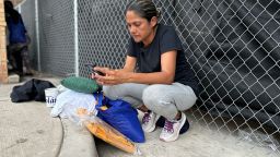 Diocelina Querales checks her phone for messages from family members