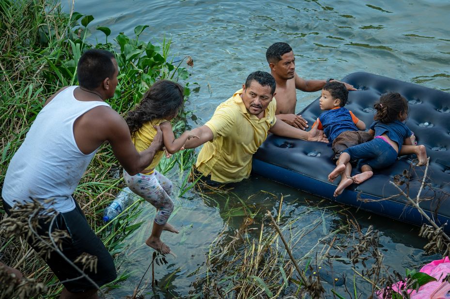 Migrants climb onto an air mattress in Matamoros to prepare to cross the Rio Grande toward Brownsville, Texas, on May 11.