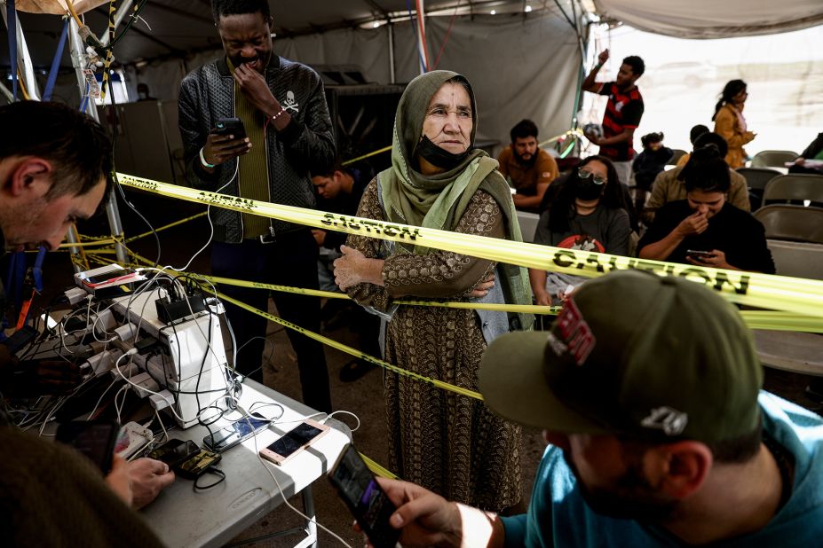 Migrants released by US border officials are seen at a cell phone charging station at the Regional Center for Border Health in Somerton, Arizona, on May 11.