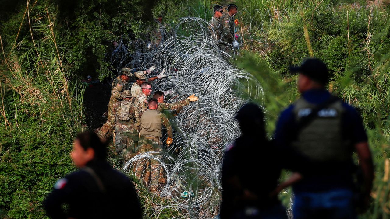 Texas National Guard soldiers place more razor wire on the banks of the Rio Bravo river in Matamoros, Mexico, before the lifting of Title 42 on May 11, 2023.
