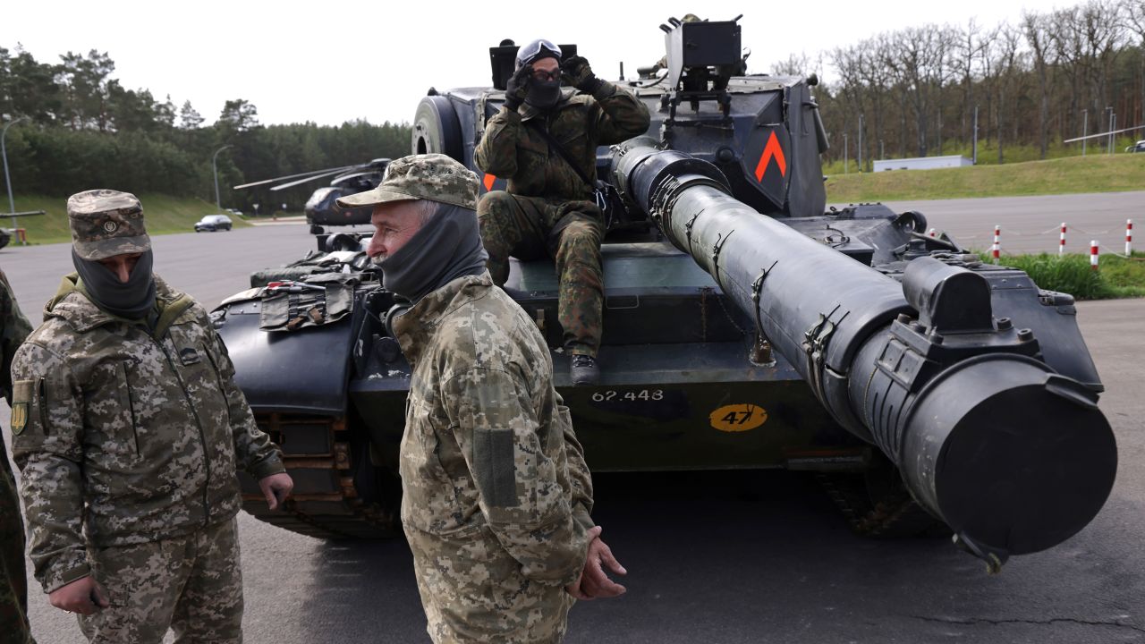 A Ukrainian tank crew stand by the Leopard 1A5 main battle tank they are being trained to operate and maintain by German and Danish military personnel at a military training ground of the Bundeswehr on May 5, 2023.