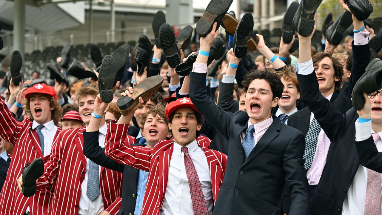 Eton schoolboys cheer on their team from the stands.