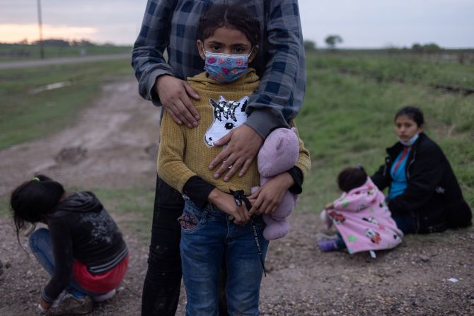 Alison, a 6-year-old migrant from Honduras, stands with her mother while they wait to be transported to a US Border Patrol processing facility in La Joya, Texas, on May 13.