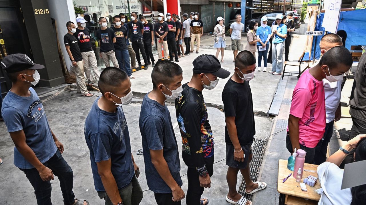 Thai troops wait in a queue to cast their ballot at a polling station during Thailand's general election in Bangkok on May 14, 2023.