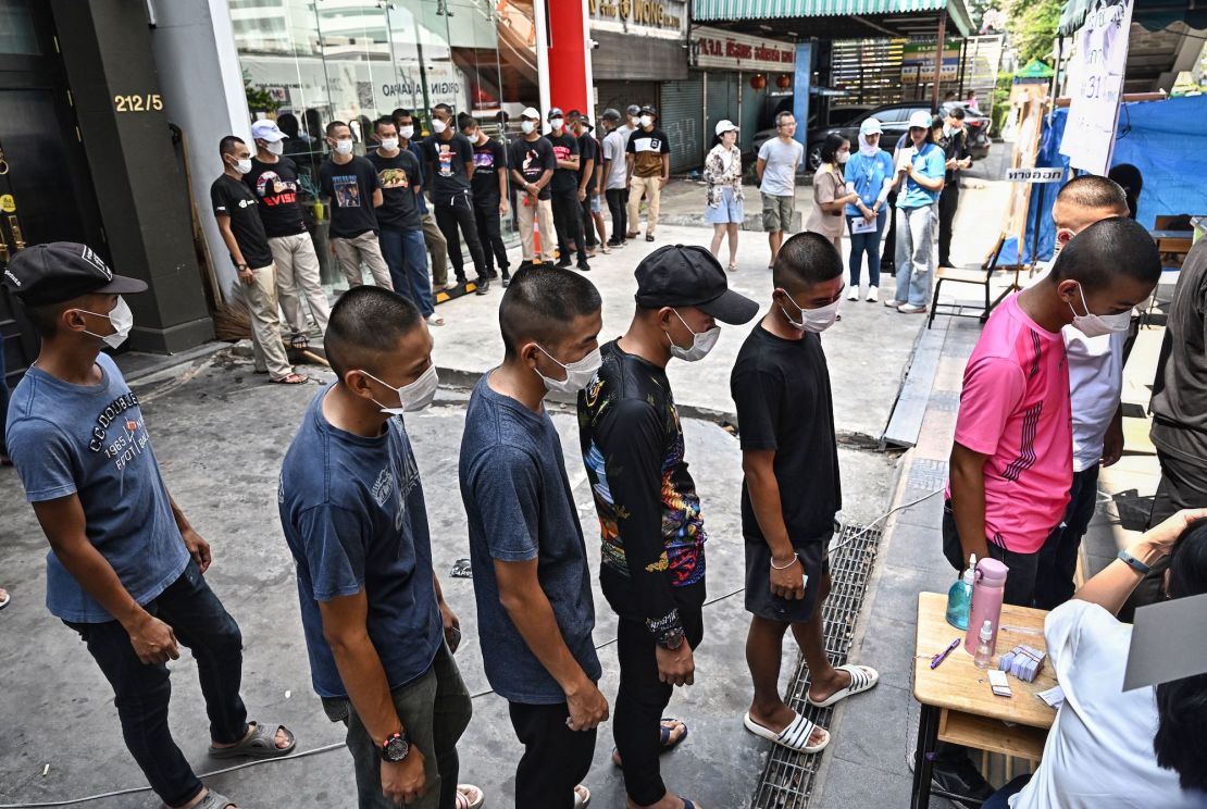 Thai troops wait in a queue to cast their ballot at a polling station during Thailand's general election in Bangkok on May 14, 2023.