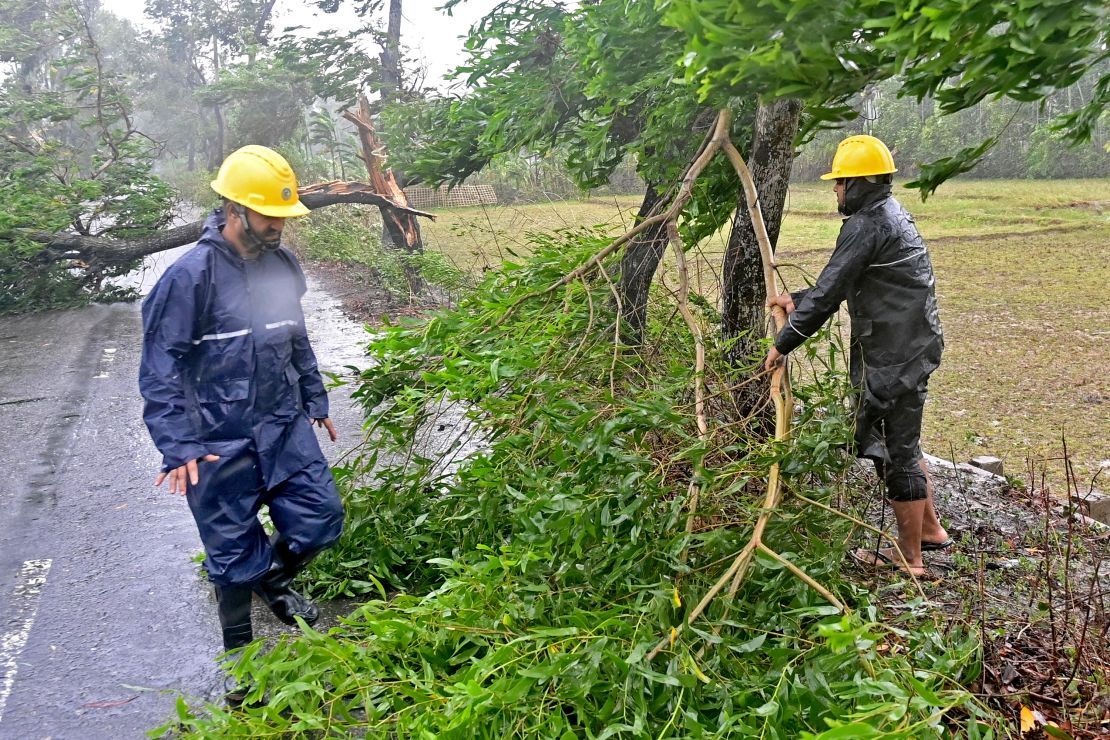 Rescue team remove fallen trees to clear a road in Teknaf.