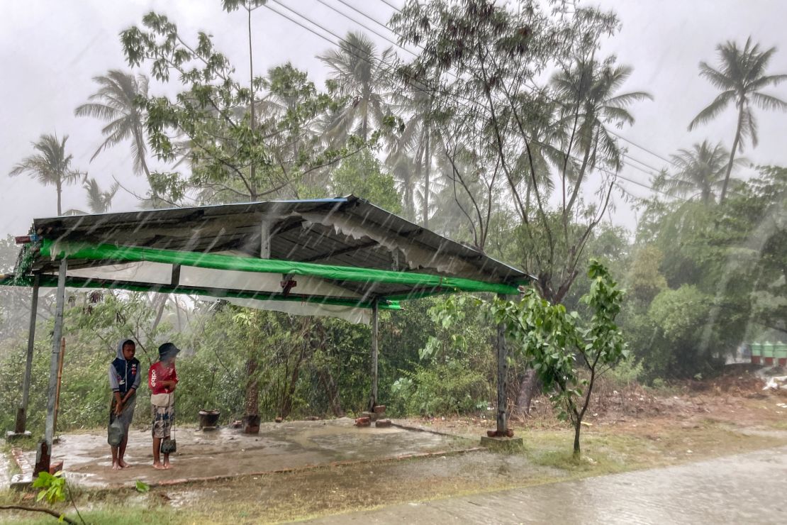Two children stand under a roadside shelter to protect from rain before Cyclone Mocha hits in Sittwe, Rakhine State, on Sunday, May 14, 2023. 