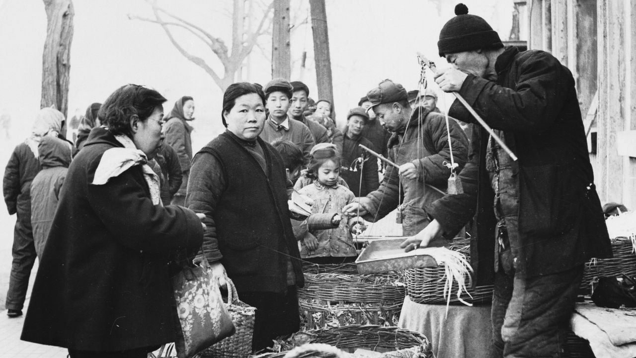 May 1959: Customers buying fresh vegetables from a market in Beijing (Peking), China's capital city. 