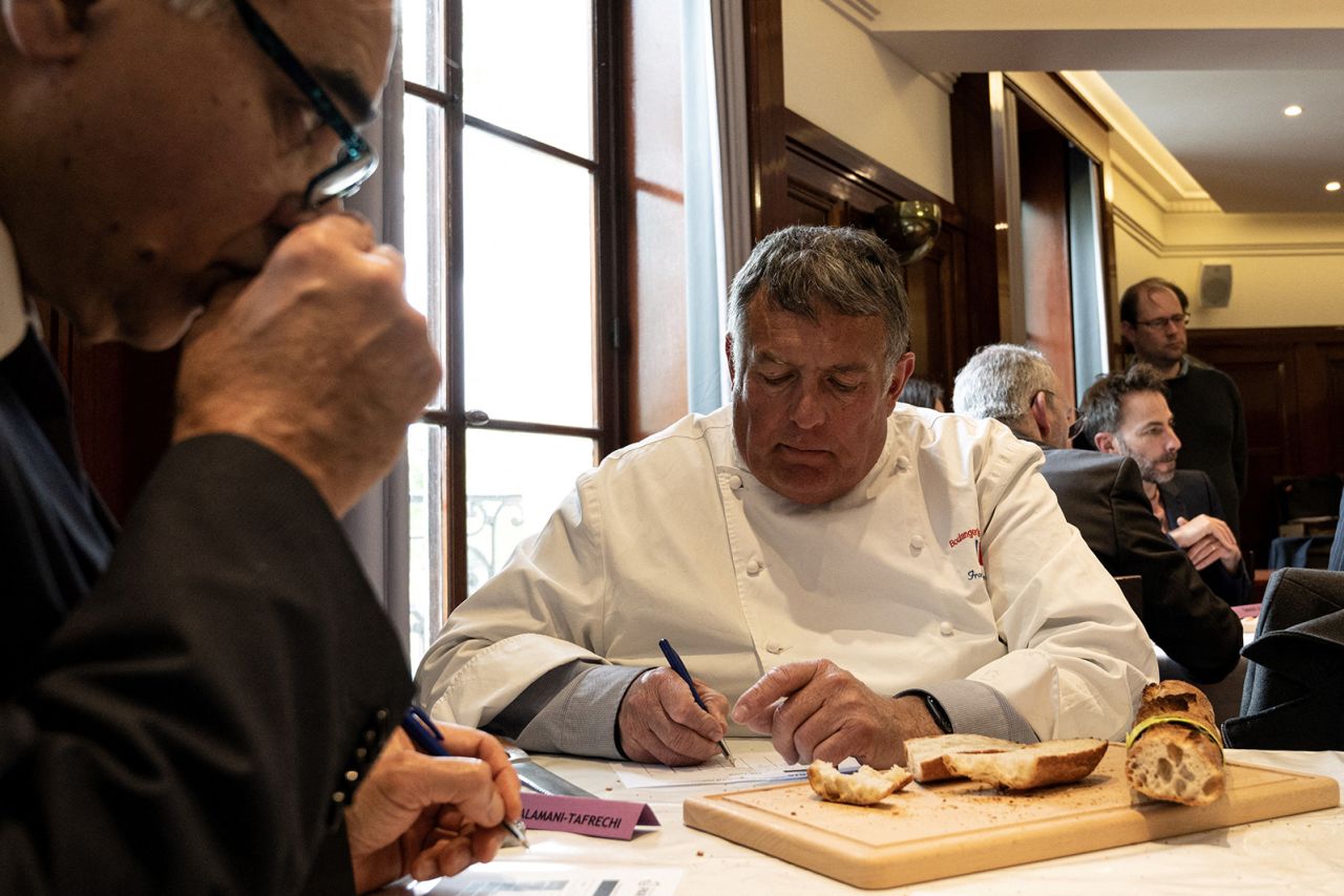 A member of the jury inspects baguettes for the 2023 contest.