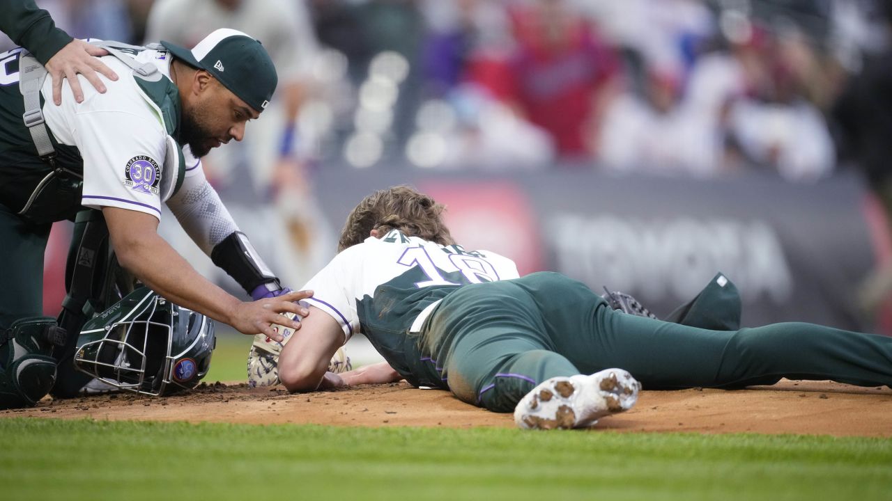 Colorado Rockies catcher Elias Díaz (left) checks on pitcher Ryan Feltner after he was hit by a line drive from Philadelphia Phillies right fielder Nick Castellanos. 